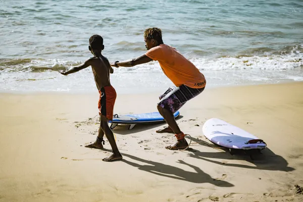 Kabungo teaching a young student on the beach