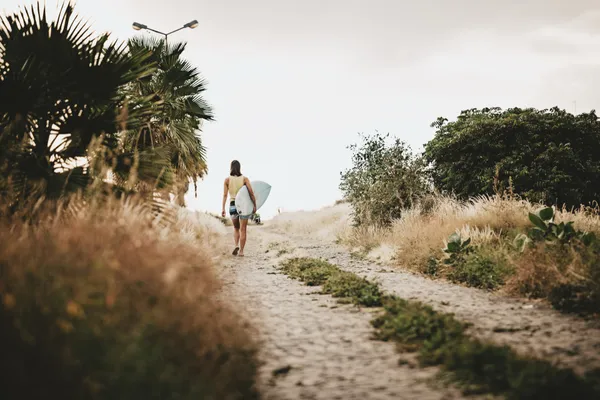 Surfer on cobblestone path
